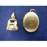Small 9ct yellow gold oval locket and a yellow coloured metal seal, gross weight 7.3g, all stamped