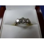 Three stone diamond ring on a yellow coloured metal shank, unmarked size M