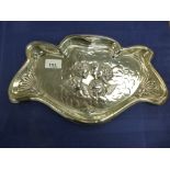 Art Nouveau silver trinket tray with shaped asymmetrical edge, centre embossed with cherub heads,