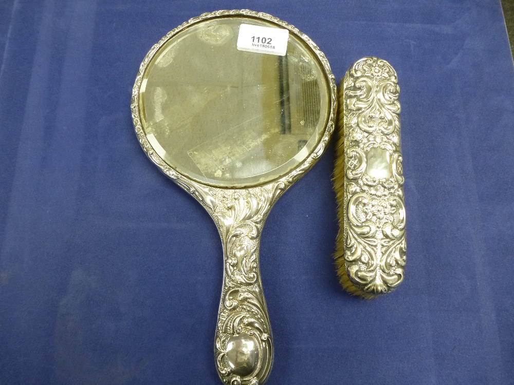 Edwardian Silver backed hand mirror with embossed decoration, Birmingham 1908 and matching clothes