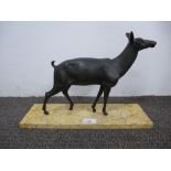 A bronzed figure of a deer on a rectangular marble base