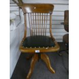 A stamped beech stick back revolving desk chair