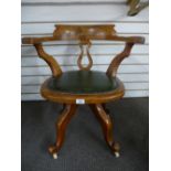 An antique walnut revolving desk chair with green leather seat