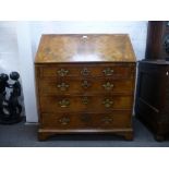 An antique Possibly Queen Anne burr Walnut bureau with 4 long graduated drawers on bracket feet 95cm