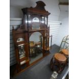 An Early 20th Century walnut over mantel mirror with carved decoration and turned supports