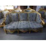 A French carved giltwood salon suite comprising of a settee and a set of four arm chairs