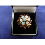 1970's cluster style dress ring set with 7 opals & 18 rubies on a yellow coloured metal shank size