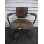 An industrial style revolving desk chair, with leather upholstery