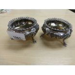 Pair of Victorian silver circular salts with embossed floral decoration, gadroon edges, on 3 hoof