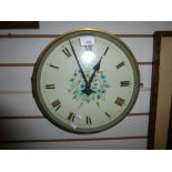 A round brass wall clock having floral painted dial, 32.5cms.