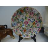 Oriental floral painted dish, characters to the base, chip to the rim