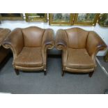 A pair of brown leather arm chairs on square moulded