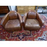 A pair of 1930's style brown leather tub chairs