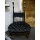 A Victorian black and gilt nursing chair having buttoned seat