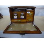 An Edwardian Oak travelling stationery box, with glazed door with fitted interior