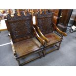 A pair of antique style oak open arm chairs having floral carved backs