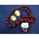 Long Cherry Amber graduated bead necklace, approx. 45cm long, 90g, together with 2 cameo shell