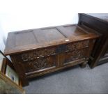 An antique oak coffer probably mid 18th Century, the front carved stylised tulips, 104cms