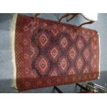 An old Bokhara rug having diamond medallions in a brown field 198 X 124cms