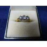 Three stone diamond ring on an 18ct yellow gold shank, stamped 750, size M/N