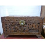 Chinese carved camphor wood blanket box decorated with figures and pagodas, 97cm