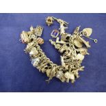 Heavy silver charm bracelet hung with approx. 40 charms, including Concorde, Noah's Ark, London Bus,