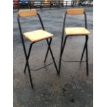 A pair of folding kitchen stools with beech seats and bar backs, on folding tubular metal frames. (