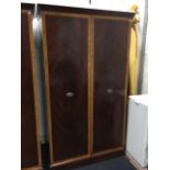 A large mahogany wardrobe with satinwood crossbanded doors enclosing shelves & hanging space, raised