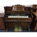 A walnut cased harmonium, with applied scroll carving and five octave keyboard with twelve stops,