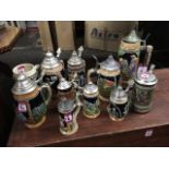 A collection of German stoneware steins with hinged metal covers. (11)