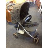 A Babystart childs folding pushchair, complete with raincover.
