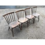 A set of four spindleback chairs, with rounded back rails and shaped seats, raised on turned