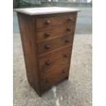 A small Edwardian oak chest of five graduated drawers mounted with knobs, beneath moulded top.