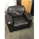 A large leather upholstered armchair with deep seat and padded platform arms, raised on block feet.