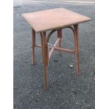 A square Lloyd Loom style painted occasional table, raised on angled legs joined by crossed