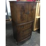 A reproduction bowfronted mahogany cabinet with plate glass top above oval flame veneered doors