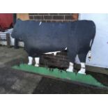 A large painted farm sign, cut from sheet metal depicting a bull on field.