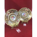 A pair of fine Austrian porcelain floral cabinet plates, painted with polychrome flower panels on