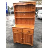 A pine dresser, the delft rack with open shelves above a base with two frieze drawers and panelled