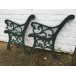 A pair of cast iron bench ends with scrolled arms on channelled legs - lacking slats. (2)