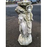 A composition stone garden stand, moulded as the three graces around a draped foliate moulded