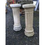 A pair of fluted composition stone garden pilasters, with octagonal plinth bases and circular