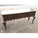 A Georgian style oak dresser, the crossbanded moulded top above three frieze drawers mounted with