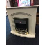 A painted fire surround with arched aperture framing electric heater with faux coals and brass