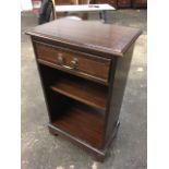 A mahogany crossbanded cabinet with drawer above open shelves, raised on bracket feet.