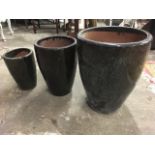 A graduated set of three terracotta garden pots in mottled green/brown glaze. (3)