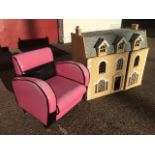 A dolls house with three dormer windows, having opening front elevation with arched windows,