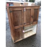 A 50s oak kitchen cabinet with panelled doors enclosing a fitted interior.