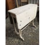 A painted Victorian sutherland table, the top with drop flaps and canted corners on twin fluted