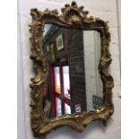 A rococo style gilt mirror, the pierced frame moulded with shell crest and foliate scrolling, the